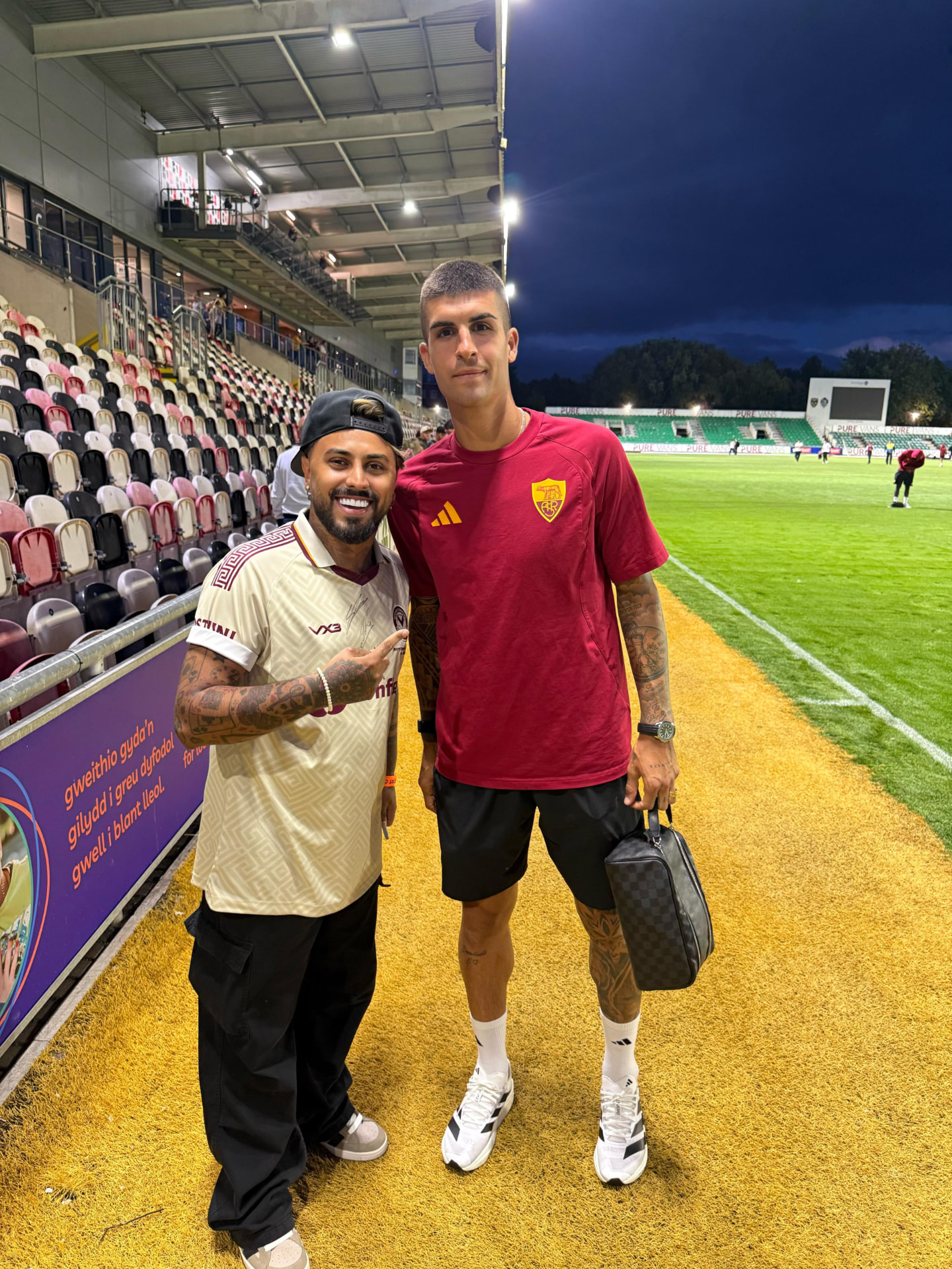 Gerryn Hussain pitch-side with an AS Roma player at Rodney Parade