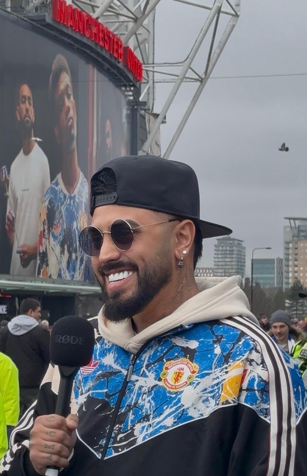 Gerryn Hussain outside Old Trafford with a RØDE microphone