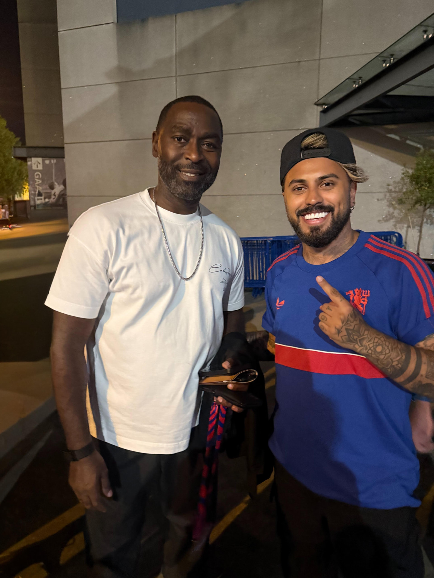 Gerryn Hussain with Andy Cole outside the stadium at night
