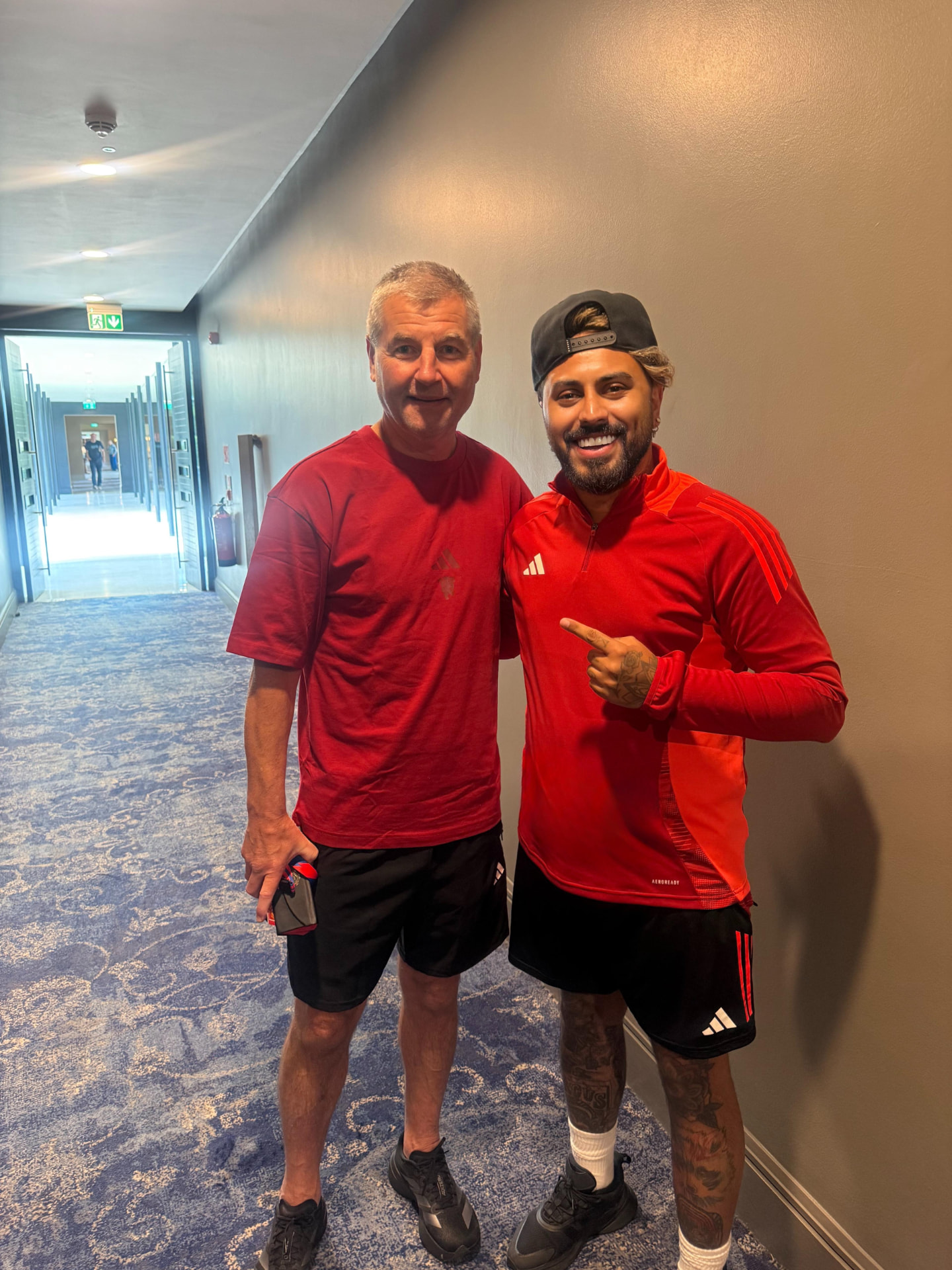 Gerryn Hussain in red training kit in a hotel corridor before a match